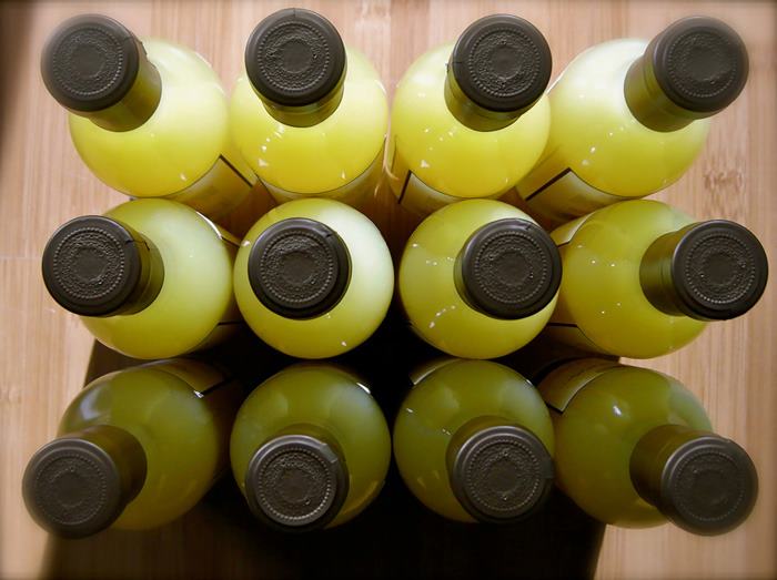 Bottles of Italian limoncello with yellow caps racked in a cellar